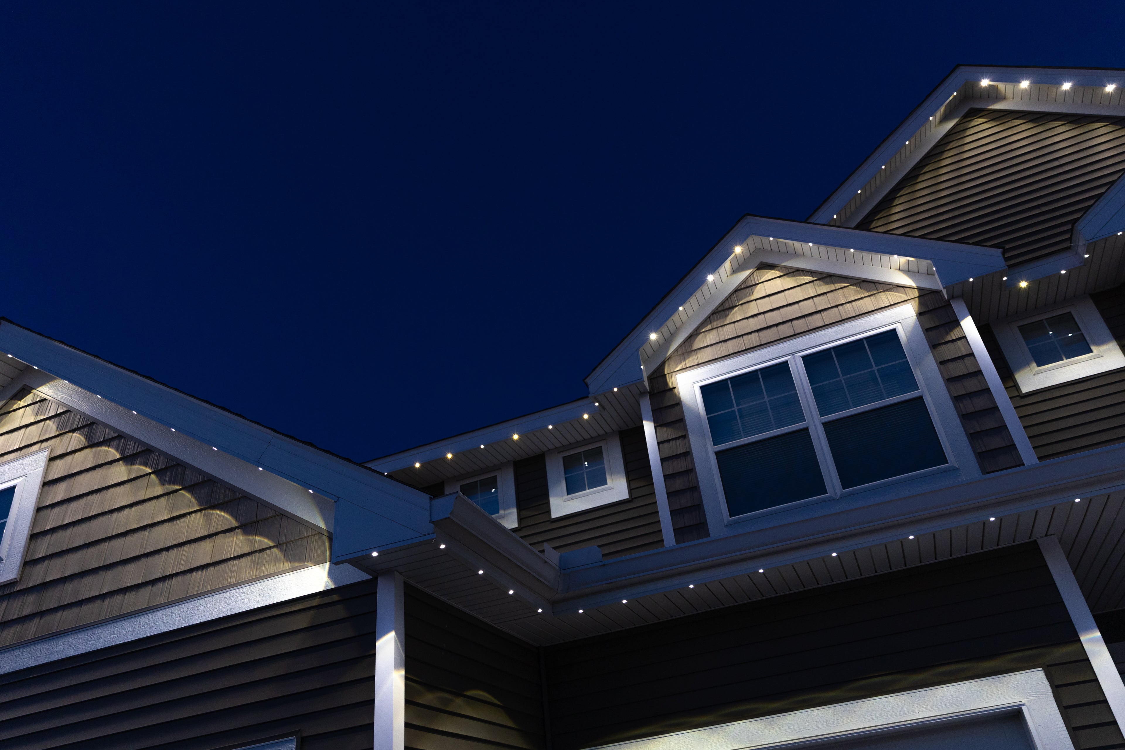 House exterior with Govee permanent track lighting lights on the roof at night